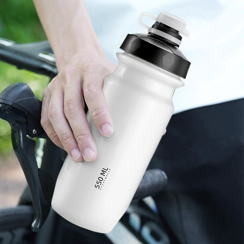 On The Go 550ml Leak Proof Bike Water Bottle With Hands Free Bite Valve held beside a bike
