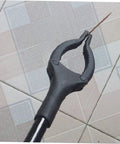 Extendable Garbage Grabber Stick With Smooth Clamp holding a small twig on tiled floor