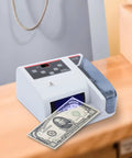 Portable Money Counter Machine With LED Display And Auxiliary Bracket Hands Free Operation on wooden desk