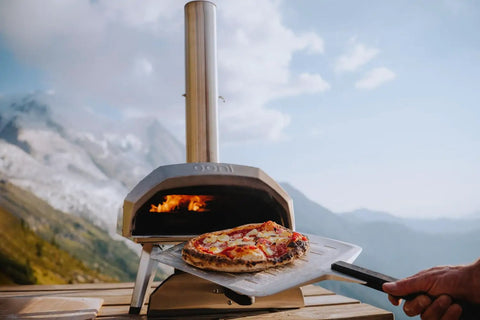 Perforated Aluminum Pizza Peel 12 Inch With Long Handle Lightweight Rectangle Turning Spatula Paddle For Oven Transfer in use