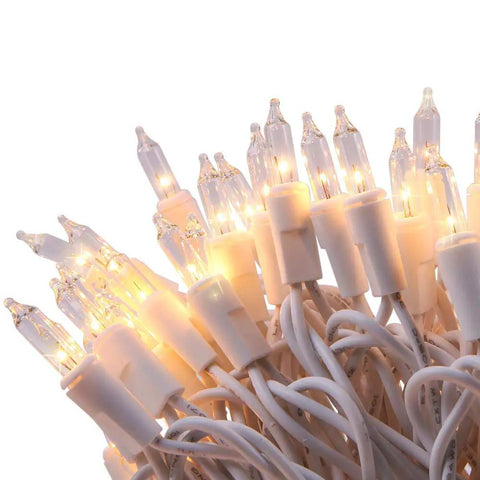 Close-up of ultra bright clear mini Christmas tree lights 21.45Ft 100 bulbs on white cord for indoor outdoor decor, warm glow.