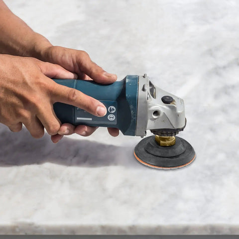 Hand using a grinder with 13 Pack 4 Inch Diamond Polishing Pads With Five Eighths Inch 11 Backer Pad Wet Dry Kit on stone