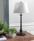 68 Inch Tall Floor Lamp With White Linen French Drum Shade In Blackened Bronze Finish on wooden table with plants