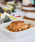 Game-Changing Silicone Turkey Baster With Cleaning Brush in use on roasted turkey, easy bulb syringe tool in white pan
