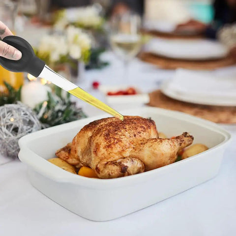 Game-Changing Silicone Turkey Baster With Cleaning Brush in use on roasted turkey, easy bulb syringe tool in white pan