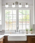 Four Light Vanity Lighting Fixture With Globe Seeded Glass Shades In Brushed Nickel Finish Over Kitchen Sink