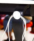 Heavy-Duty Removable Round Adhesive Hook And Loop Tapes for Wall Mounting attached to black table leg with cords secured