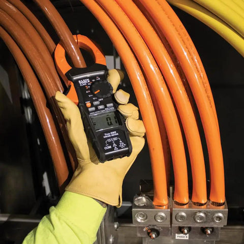 Person using Digital Clamp Meter With Auto Range TRMS For AC DC Voltage And Current Up To 2000A in electrical testing