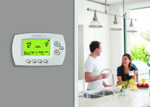 Smart 7-Day Wi-Fi Programmable Thermostat With Energy Star Rating on wall, couple in kitchen