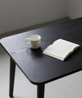 Dope Matte Black Peel And Stick Wood Texture Wallpaper Roll 16 Inch By 120 Inch Self Adhesive Cover For Countertops Cabinets Desks And Bathrooms Easy To Cut Removable Kitchen Decor applied to a tabletop with a mug and book on top.