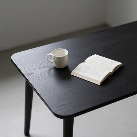 Dope Matte Black Peel And Stick Wood Texture Wallpaper Roll 16 Inch By 120 Inch Self Adhesive Cover For Countertops Cabinets Desks And Bathrooms Easy To Cut Removable Kitchen Decor applied to a tabletop with a mug and book on top.