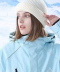 Person wearing a white knit beanie and light blue winter jacket in snowy landscape, not a 2 In 1 Balaclava Ski Mask For Cold Weather Warm Face Cover And Beanie Hats For Men Navy Knit Cotton Breathable Warmth With Stretchable Comfort Snug Fit All Day Winter Gear.