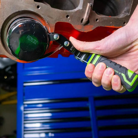 Swivel Oil Filter Wrench For 4-3/4 To 5-3/4 Inch Filters being used on engine with green padded TPR handle