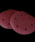 Rock Solid 50 Pack Of 9 Inch Aluminum Sanding Discs With 6 Holes And Hook Loop Backing stacked on black background.