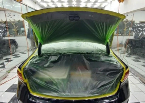 Car trunk covered with All Purpose Automotive Masking Tape And Plastic Sheeting Kit, Multi Size Pack, Pre Taped Masking Film in garage