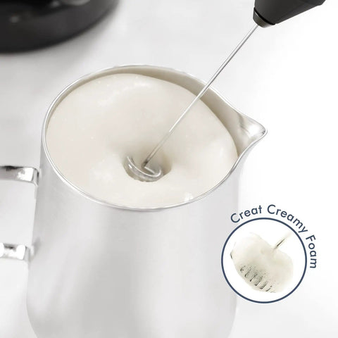 Mini Handheld Milk Frother Wand With Stainless Steel Whisk Battery Powered Drink Mixer For Coffee Lattes Cappuccinos and Matcha No Stand Needed Portable Barista Style Foam On The Go Gift For Coffee Lovers Black creating creamy foam in a pitcher.