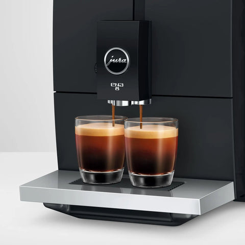 Smooth Operator Fully Automatic Coffee Machine Featuring A Smart Touchscreen And One Touch Milk Drinks In Polished Metropolitan Black brewing espresso into two glasses.