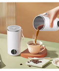 Grab And Go Heated Self Stirring Mug Electric Magnetic Mixing Travel Cup pouring hot coffee into a cup on a table.