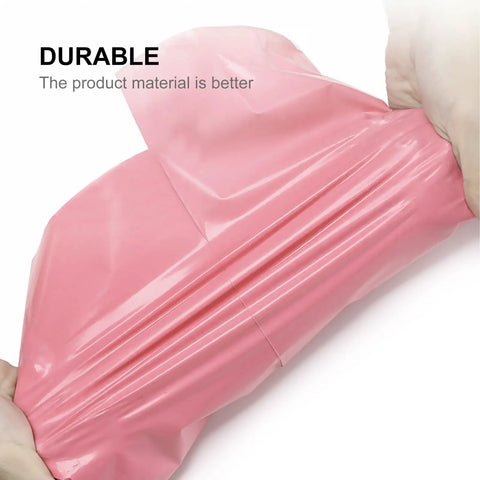 Close-up of a pink waterproof self sealing mailing bag made from sturdy PE plastic being stretched, showing durability.