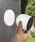 Hand holding Google Nest Cam near Magnetic Wall Mount For Google Nest Cameras Indoors Or Outdoors Battery 2nd Generation Replacement Base Plate Strong Hold And Easy Setup Flexible Angles Nest Cam Not Included.