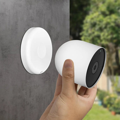 Hand holding Google Nest Cam near Magnetic Wall Mount For Google Nest Cameras Indoors Or Outdoors Battery 2nd Generation Replacement Base Plate Strong Hold And Easy Setup Flexible Angles Nest Cam Not Included.