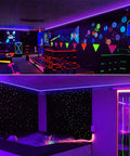 Lit 50 Foot Black Light Strip Kit With 900 LEDs 12V Flexible Lighting For Dark Parties Stage Effects Halloween And Body Paint Safe UL Adapter Easy Install installed in a glowing room for party ambiance