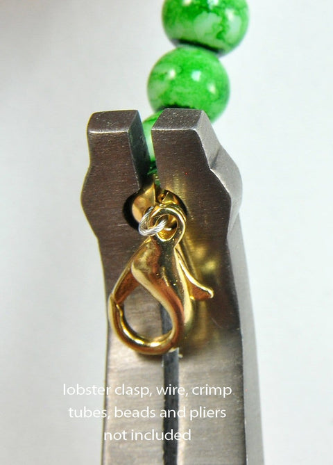 Close-up of Crimping Pliers For Jewelry Making And Beading holding a gold lobster clasp with green beads in background