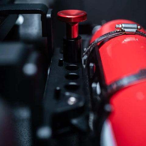 Close-up of the Slick Under Seat Fire Extinguisher Bracket For Ineos Grenadier Truck with red release knob and secure straps.