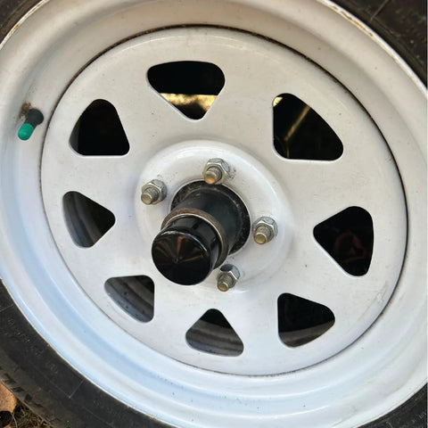 2-inch rubber wheel hub bearing dust cap plug (2-pack) on a white steel trailer wheel
