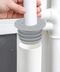 Two Pack Flexible Silicone Drain Plug For Washing Machines And Floor Drains shown in gray, being placed into a sink pipe for easy installation.