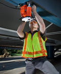 Worker using Heavy Duty Magnetic Drill Sized For One Point Six Two Five Inch Boring on steel beam in safety gear.