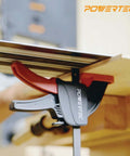 POWERTEC track guide rail clamp installed to wooden rail; black body with red insert and branding visible
