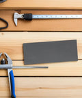 Rock Solid 21 Piece Grit Emery Sandpaper Sheets placed on wooden surface with measuring tools for automotive refinishing.