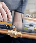 Hand installing Premium Full Port Brass Ball Valve With Drain 3/4 In SWT X 3/4 In SWT on copper piping. © Alt Tag