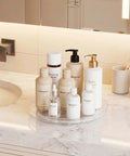 Smooth Spin Bathroom Vanity Tray For Counter 2 Pack 9 Inch Rotary Makeup Organizer with skincare products on marble countertop.