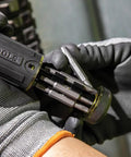 Close-up of gloved hands holding Ratcheting Multi-Bit Screwdriver 15-In-1 With Phillips Slotted Square Torx bits open on-handle storage.
