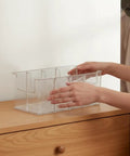 Person arranging Top Shelf Crystal Clear Acrylic Belt Organizer With Removable Dividers Stackable Storage Bin for ties and watches.