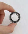 Hand holding Two Pack 17287-2RS Deep Groove Ball Bearings 17x28x7mm Steel With Black Sealed Covers For Cycling MTB Mountain Road Bikes