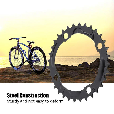 32T 104mm BCD Steel Round Chainring For 9 Speed Mountain Bikes Beefy Steel Build With Quiet Ride And Top Notch Chain Retention Durable MTB Replacement Part showcased near a mountain bike on rocky terrain at sunset