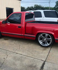 Side view of red Chevy Silverado 1500 1988 to 1998 with lowering kit, featuring 5 inch front drop spindles and 7 inch rear flip kit.