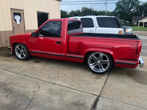Side view of red Chevy Silverado 1500 1988 to 1998 with lowering kit, featuring 5 inch front drop spindles and 7 inch rear flip kit.