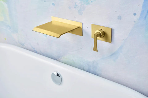 High Flow Wall Mount Tub Filler With Single Lever Large Waterfall Spout CUPC Certified Pressure Balance Rough In Valve Included Brushed Gold Finish Modern Bath Upgrade For Spa Vibes And A Handy Shelf For iPad Candles Or Glassware featuring a brushed gold finish with a modern minimalist design against a colorful wall backdrop.