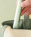 Hand placing 3 Pack 2 In 1 Needle Threader And Seam Ripper Set For Sewing Threading And Seam Removal into a green and cream bag