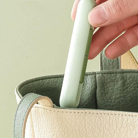 Hand placing 3 Pack 2 In 1 Needle Threader And Seam Ripper Set For Sewing Threading And Seam Removal into a green and cream bag