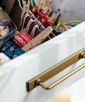 Two Pack 5 Inch Center To Center Antique Brass Cabinet Bar Pulls With Backplates installed on white drawer corner