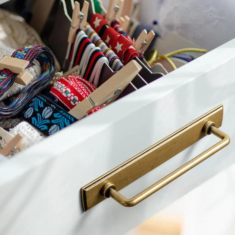 Two Pack 5 Inch Center To Center Antique Brass Cabinet Bar Pulls With Backplates installed on white drawer corner