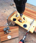Front view of yellow plastic hinge drilling jig with drill attached for cabinet door installation