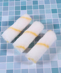 Three mini foam paint roller sleeves in white and yellow, part of the 30 Piece Mini Foam Paint Roller Sleeve Refill Set For Interior Walls Doors And Baseboards.