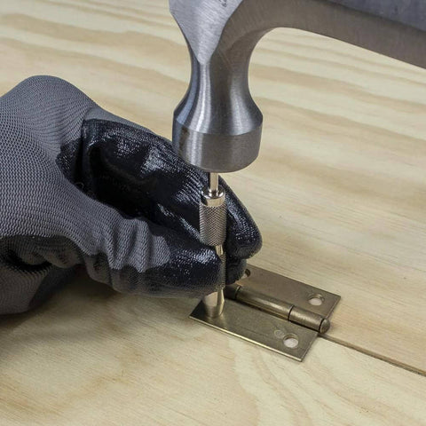 General Tools 806 Jiffy Centering Punch, silver; close-up of center punch pressed into hinge plate on wood with gloved hand