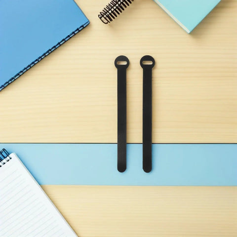 Super Solid 100 Piece Pack Of Self Adhesive Nylon Cable Ties With Cute Round Heads on a light wood surface near notebooks.
